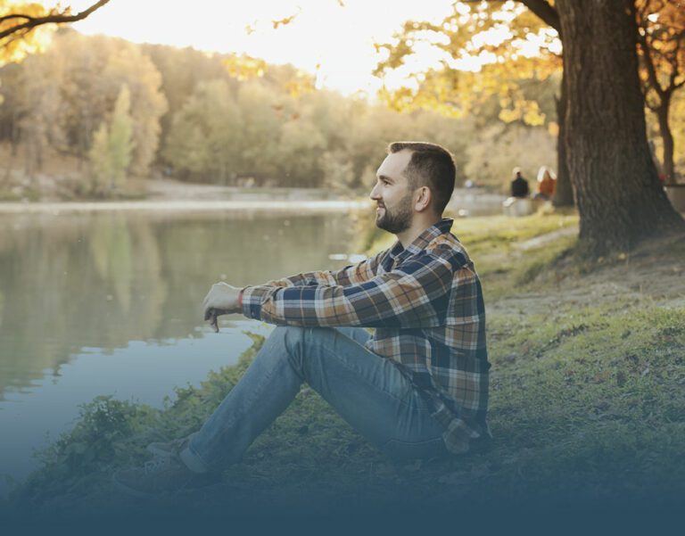 a man sits by a river as a way to celebrate world mental health day.