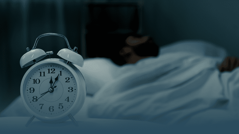 person sleeps with alarm clock nearby to depict from sleep to stress: the surprising mental health effects of daylight savings