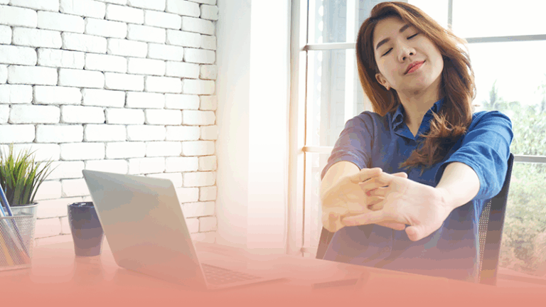 woman stretches while working at home office while learning how to use your EAP to improve wellness.
