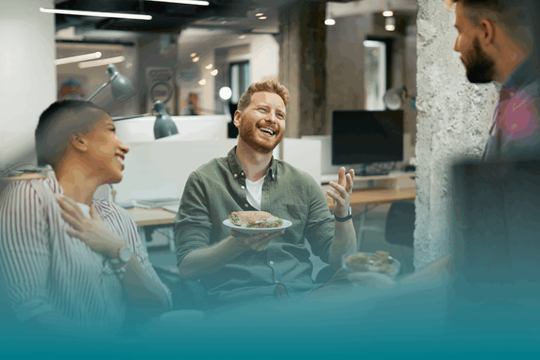 a group of coworkers sit in an office taking a break discussing how to build healthy habits at work.