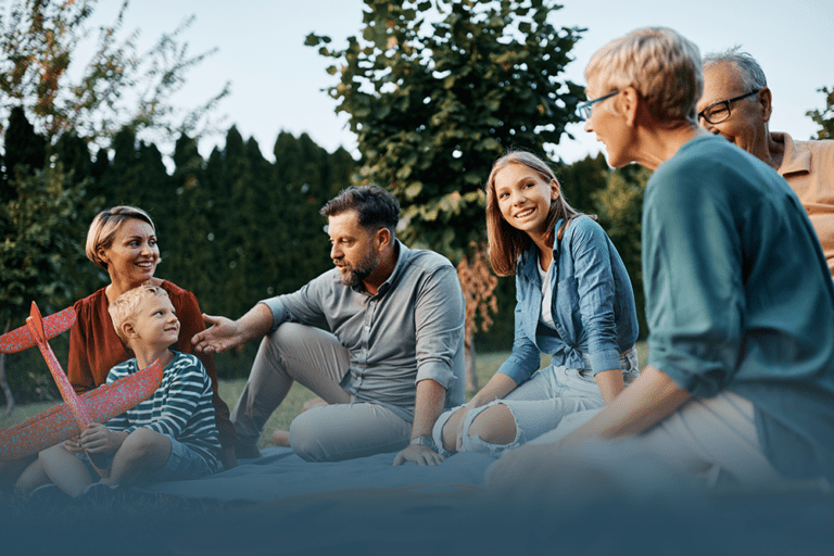 a multi-generational family sits outside enjoying the day while talking and demonstrating empowering your family to speak up about mental and physical health