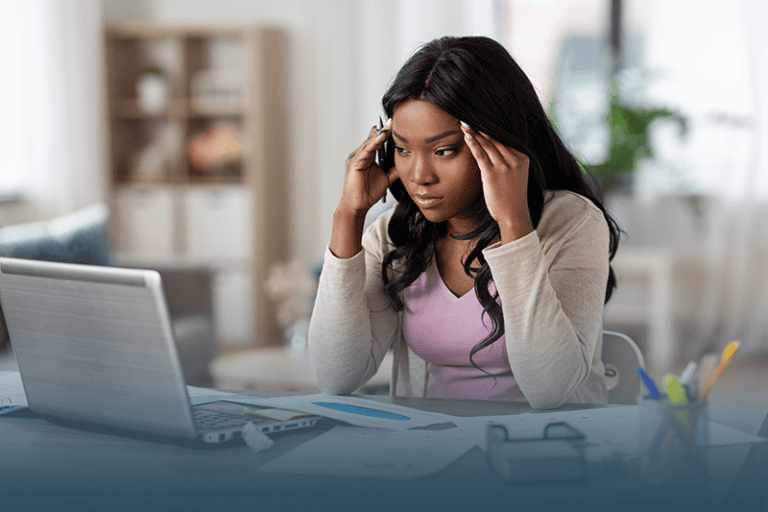 woman sitting stressed in front of a laptop demonstrating the hidden work of caregiving