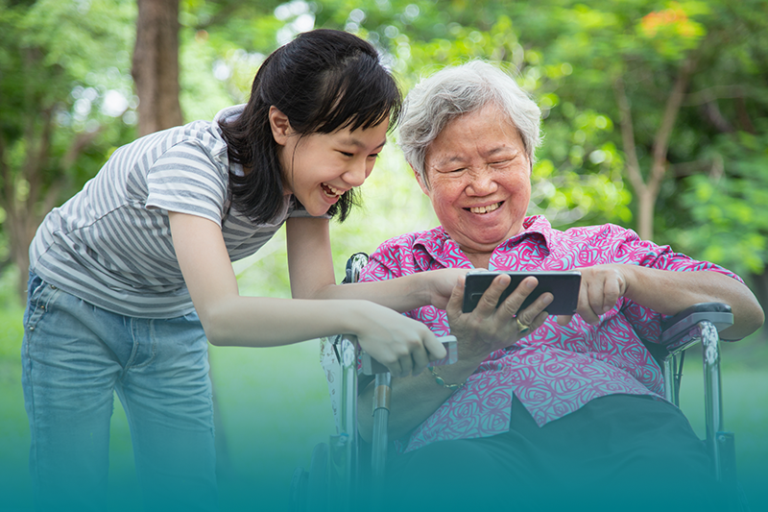 A senior and a young girl connect across generations looking at an image and memory.